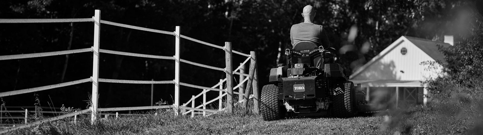 A person riding a zero-turn lawn mower powered by a Vanguard zero-turn motor.