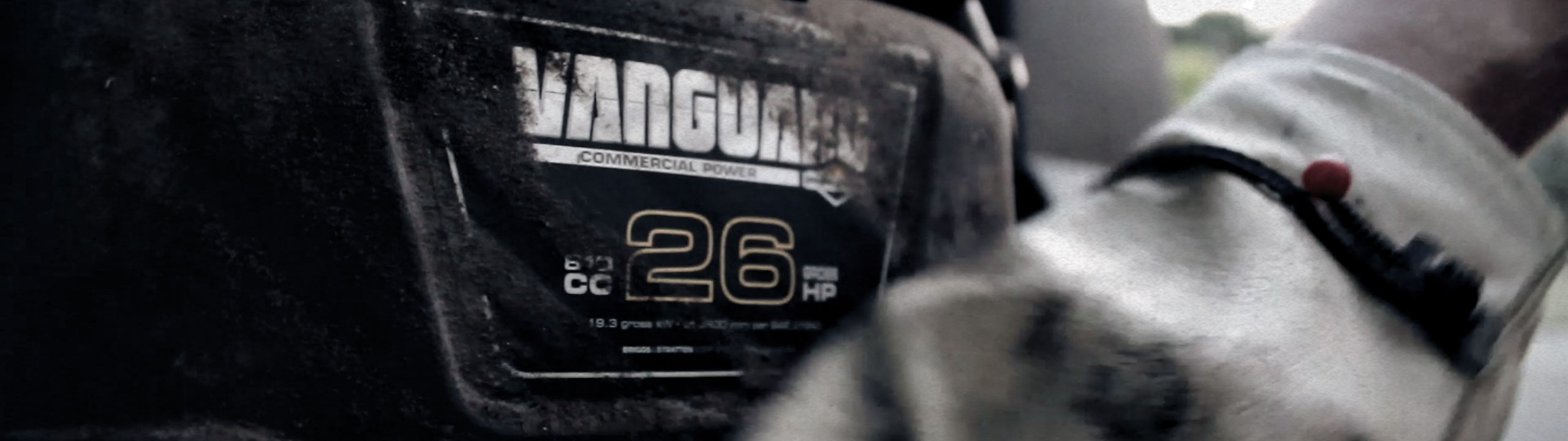 A person working on a Vanguard zero-turn Mower 26.0 Gross HP Engine.