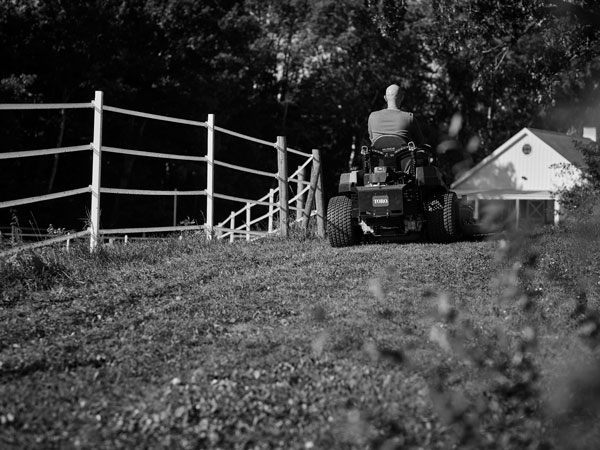 A person riding a zero-turn lawn mower powered by a Vanguard zero-turn motor.