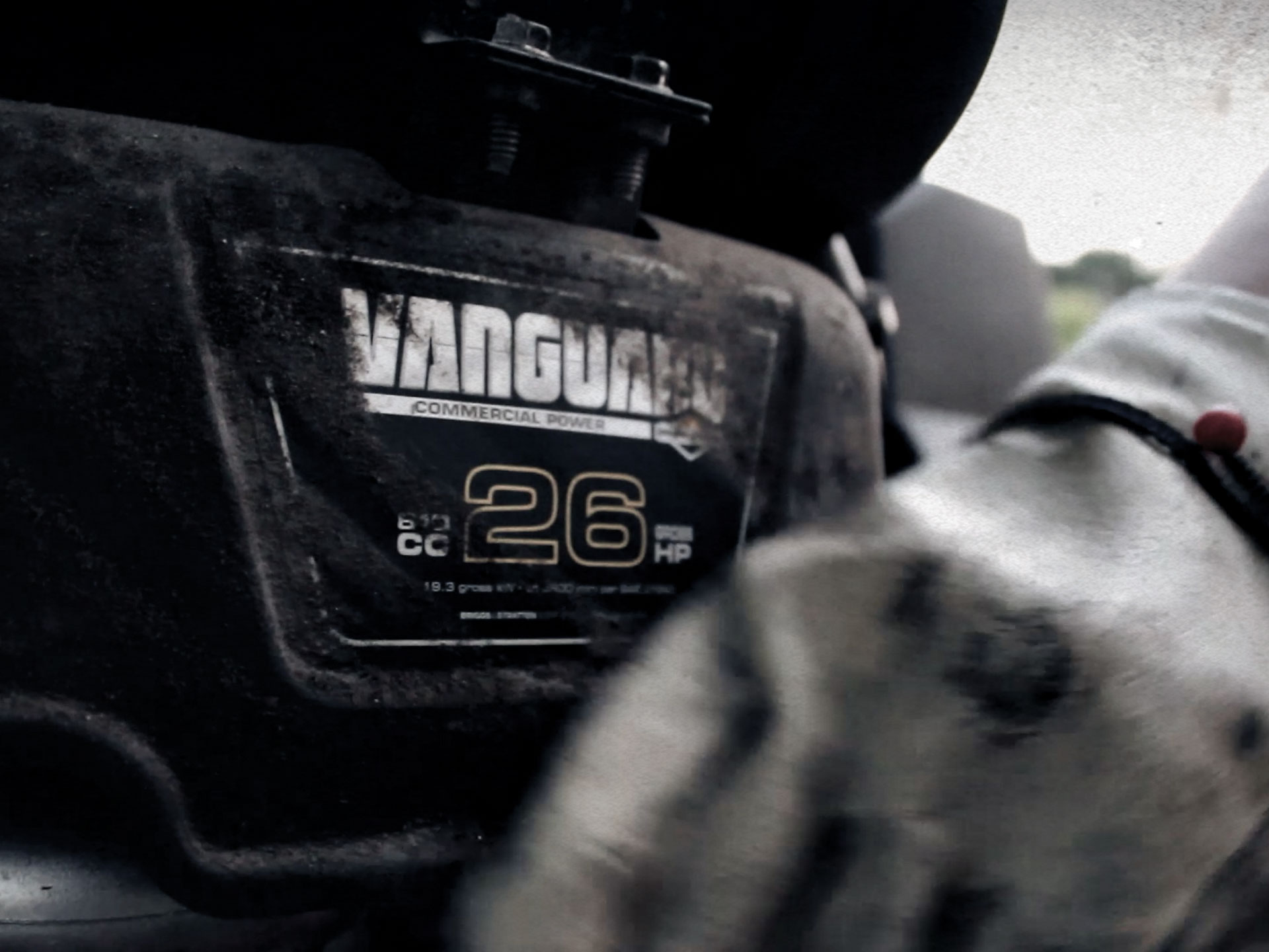 A person working on a Vanguard zero-turn Mower 26.0 Gross HP Engine.