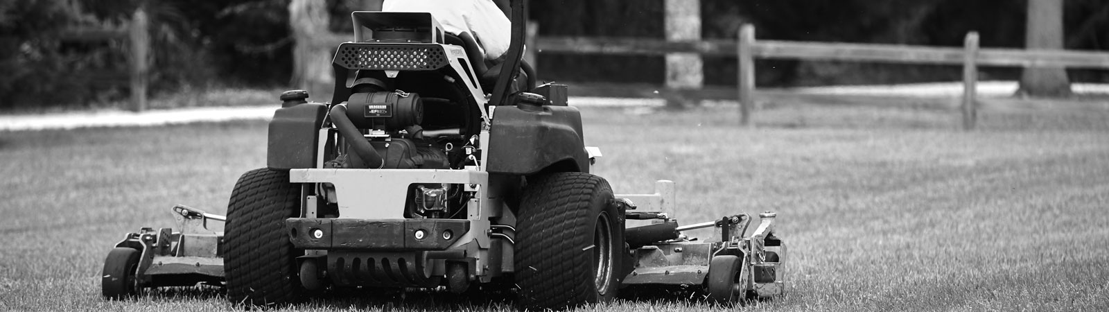 A person riding a zero-turn lawn mower powered by a Vanguard vertical shaft v twin engine.