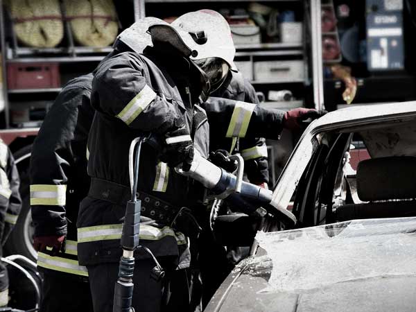 Firefighter busting car window to rescue driver