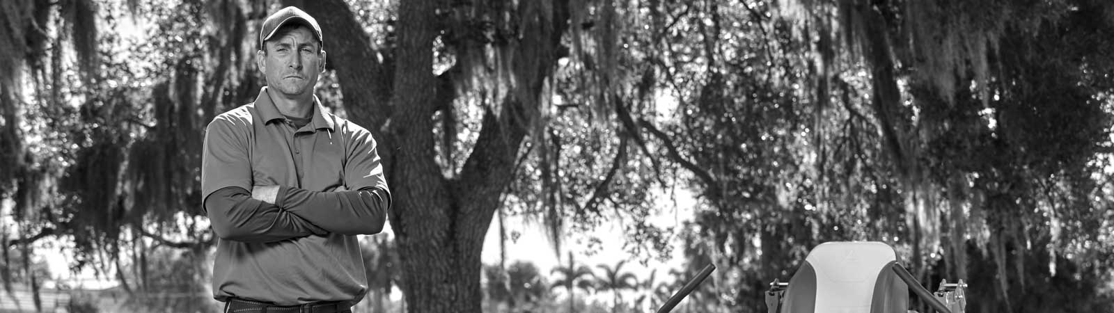Landscaper standing next to turf equipment powered by Vanguard